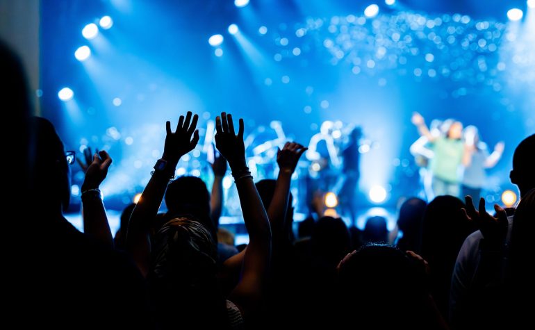 Crowd with arms raised at a concert covered by special event insurance