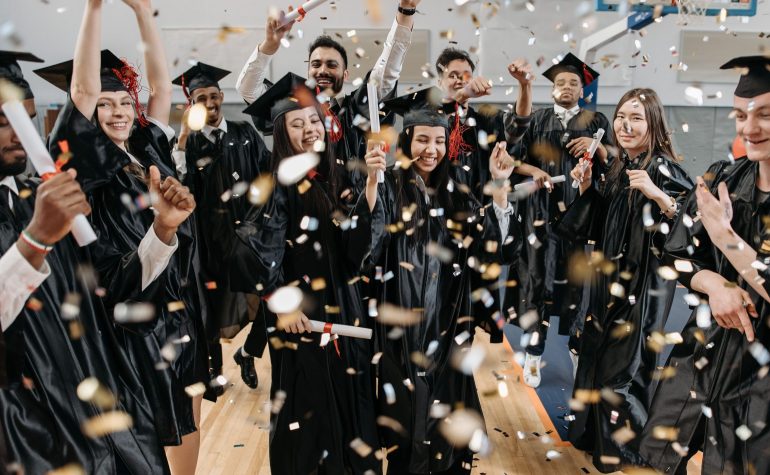 Graduates celebrating in a school gym at a covered special event
