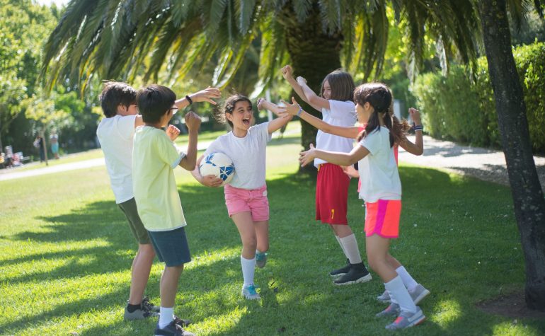 Children playing football at a summer camp